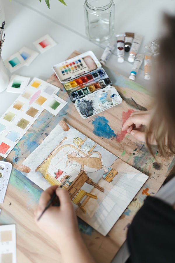 Foto-mit-Blick-ueber-die-schulter-von-Anna-Just-auf-den-arbeitstisch-der-kuenstlerin_im-Bild-zu-sehen-die-illustration-von-luzi-maus_photocredits-charlotte-jani